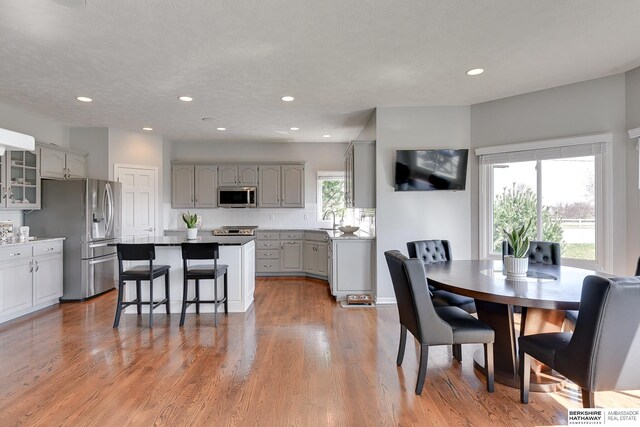 9901 S 176th St, Omaha, NE 68136 - kitchen featuring stainless steel appliances, gray cabinets, a sink, a center island, and a kitchen breakfast bar