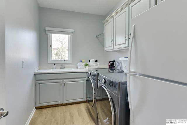 9901 S 176th St, Omaha, NE 68136 - washroom with washing machine and dryer, light wood finished floors, and cabinet space