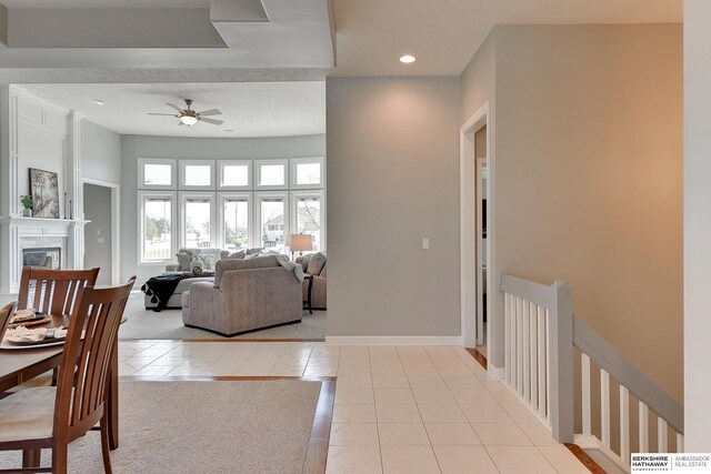 9901 S 176th St, Omaha, NE 68136 - dining area with light tile patterned flooring, ceiling fan, recessed lighting, a glass covered fireplace, and baseboards