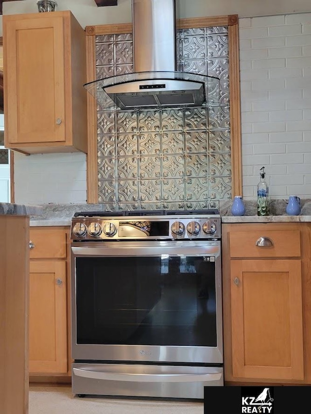 kitchen with stainless steel range with electric stovetop, island range hood, backsplash, light stone countertops, and light brown cabinetry