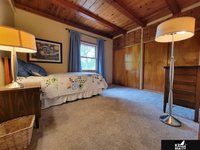 bedroom featuring beamed ceiling, wood ceiling, and carpet