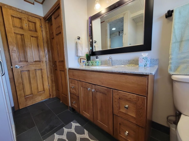 bathroom featuring toilet, vanity, and tile patterned floors