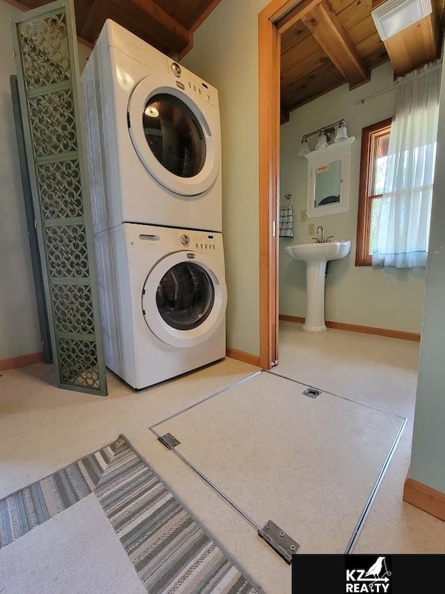 laundry area featuring stacked washing machine and dryer, wooden ceiling, and baseboards