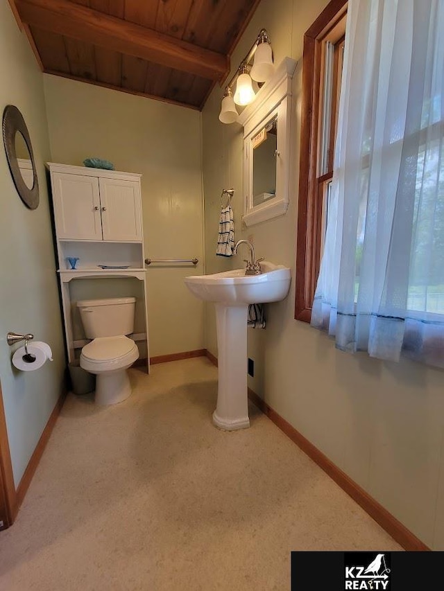 bathroom featuring wood ceiling, toilet, baseboards, and beamed ceiling