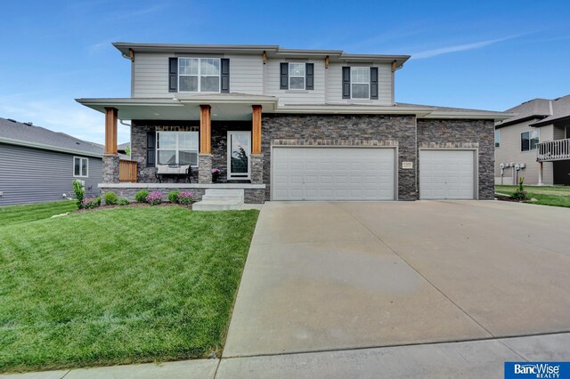 7308 Andy Dr, Lincoln, NE 68516 - view of front of house featuring concrete driveway, a front lawn, stone siding, covered porch, and an attached garage