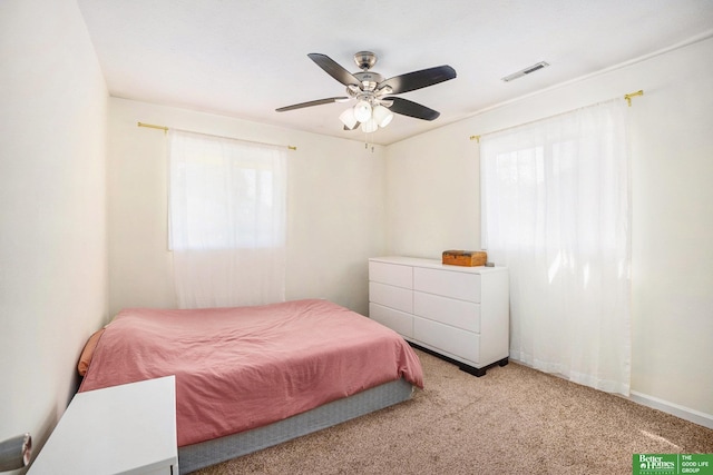 carpeted bedroom with multiple windows, ceiling fan, and baseboards