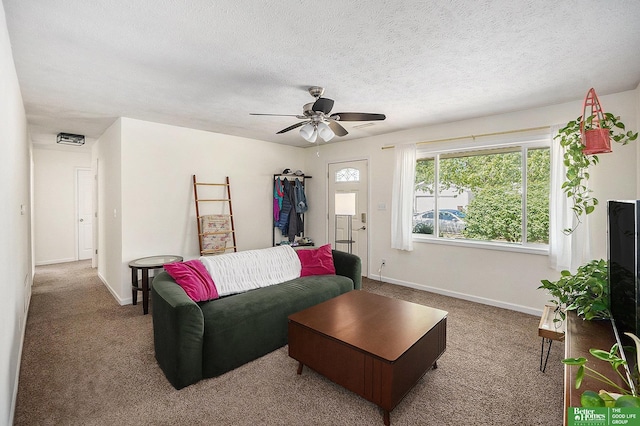 carpeted living area with baseboards, a ceiling fan, and a textured ceiling
