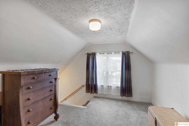 bonus room featuring light carpet, baseboards, vaulted ceiling, and a textured ceiling