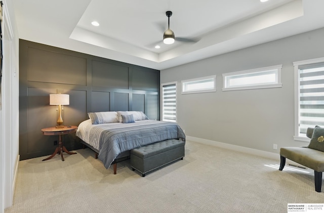 4803 N 192nd Ave, Elkhorn, NE 68022 - bedroom with a tray ceiling, recessed lighting, light carpet, baseboards, and a decorative wall
