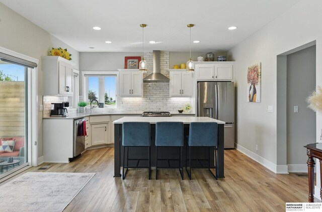 4803 N 192nd Ave, Elkhorn, NE 68022 - kitchen featuring stainless steel appliances, wall chimney exhaust hood, a center island, healthy amount of natural light, and recessed lighting