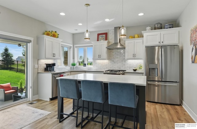 4803 N 192nd Ave, Elkhorn, NE 68022 - kitchen with stainless steel appliances, wall chimney range hood, light countertops, a sink, and white cabinets