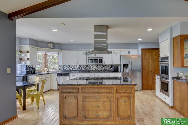 10032 Kings Dr, Omaha, NE 68142 - kitchen featuring appliances with stainless steel finishes, light wood-style flooring, island range hood, decorative backsplash, and recessed lighting