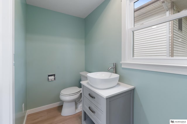 14611 Holmes St, Omaha, NE 68137 - half bathroom featuring vanity, toilet, wood finished floors, and baseboards