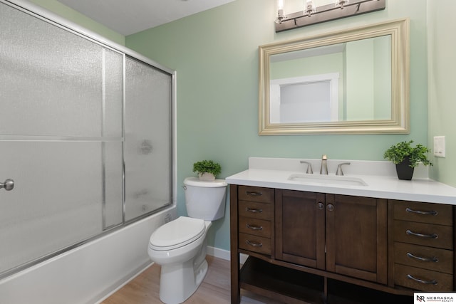 14611 Holmes St, Omaha, NE 68137 - bathroom featuring vanity, toilet, bath / shower combo with glass door, wood finished floors, and baseboards