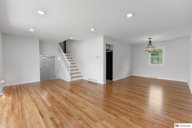 14611 Holmes St, Omaha, NE 68137 - unfurnished living room featuring stairs, light wood-style floors, recessed lighting, and baseboards