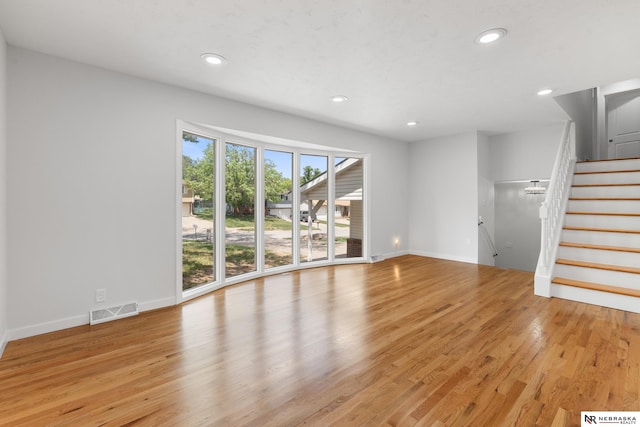 14611 Holmes St, Omaha, NE 68137 - unfurnished living room featuring light wood-style flooring, recessed lighting, stairway, and baseboards
