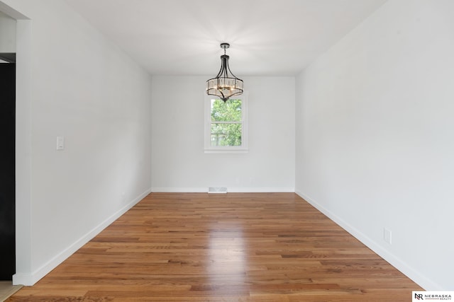 14611 Holmes St, Omaha, NE 68137 - empty room with a chandelier, wood finished floors, and baseboards