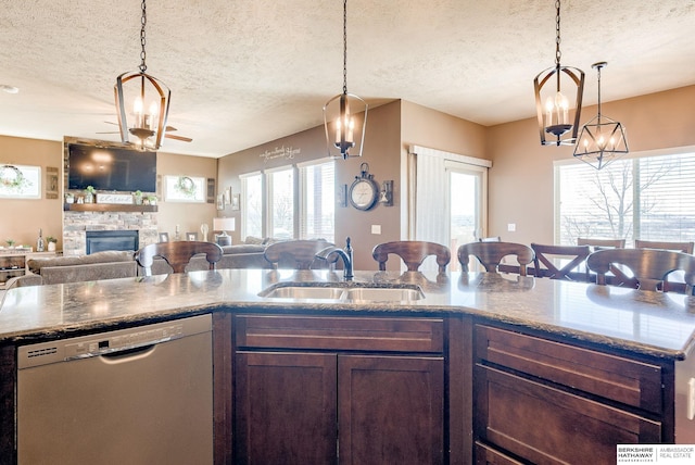 8902 N 161st Ave, Bennington, NE 68007 - kitchen featuring dishwasher, a sink, a textured ceiling, healthy amount of natural light, and a stone fireplace