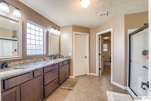8902 N 161st Ave, Bennington, NE 68007 - full bathroom featuring a stall shower, double vanity, baseboards, tile patterned floors, and a textured ceiling
