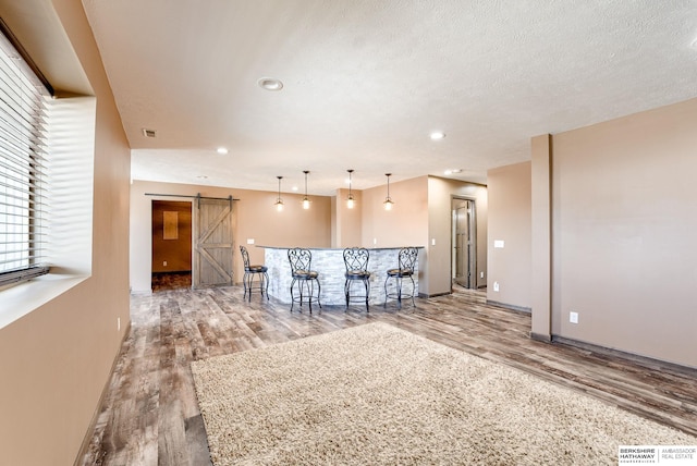 8902 N 161st Ave, Bennington, NE 68007 - kitchen featuring a barn door, wood finished floors, baseboards, hanging light fixtures, and recessed lighting
