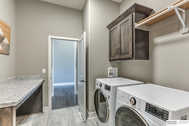 laundry room with cabinet space, independent washer and dryer, and baseboards