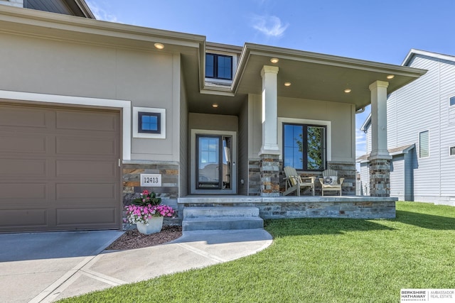 entrance to property featuring covered porch, stone siding, a lawn, and stucco siding