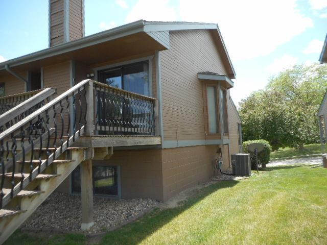 view of home's exterior featuring a chimney, a yard, central AC unit, and stairs
