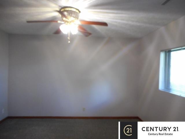empty room with a ceiling fan, carpet flooring, and baseboards