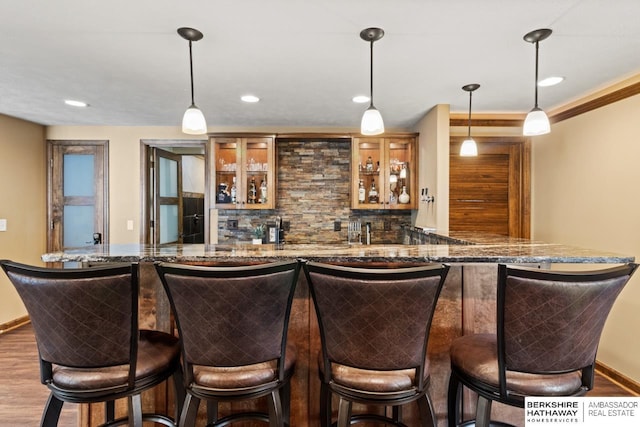 8917 N 157th St, Bennington, NE 68007 - indoor wet bar with wood finished floors, tasteful backsplash, hanging light fixtures, baseboards, and recessed lighting