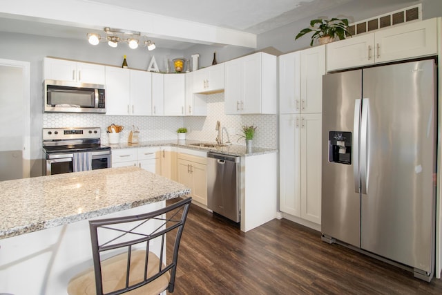 467 Steinway Rd, Lincoln, NE 68505 - kitchen featuring appliances with stainless steel finishes, a sink, dark wood-style floors, decorative backsplash, and beamed ceiling