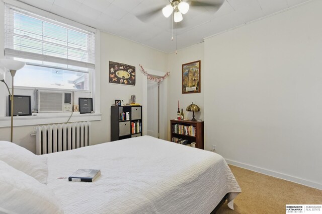 401 S 38th Ave, Omaha, NE 68131 - carpeted bedroom featuring radiator, multiple windows, baseboards, and a ceiling fan