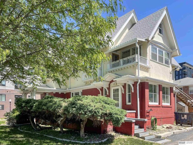 401 S 38th Ave, Omaha, NE 68131 - view of front facade with brick siding, stucco siding, a balcony, and entry steps