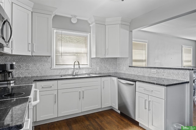 4921 Charles St, Omaha, NE 68132 - kitchen with appliances with stainless steel finishes, a sink, a peninsula, white cabinets, and healthy amount of natural light