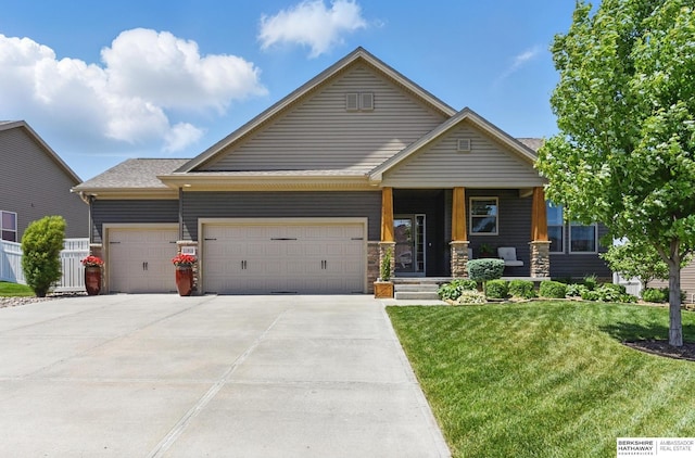 view of front of house featuring a garage, a front yard, concrete driveway, and covered porch