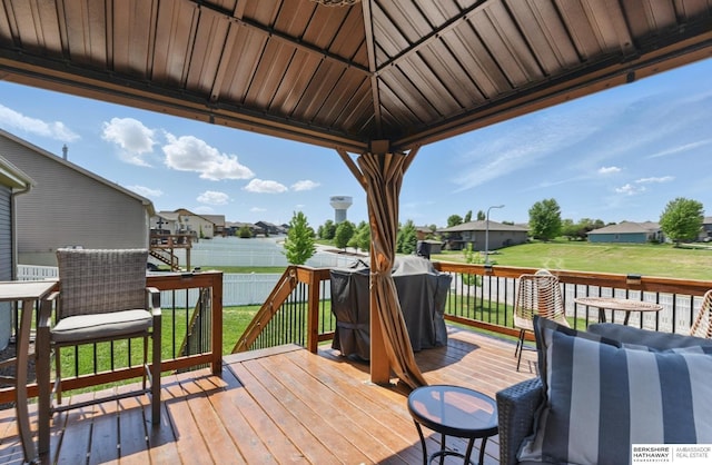 wooden deck featuring a residential view, grilling area, and a gazebo