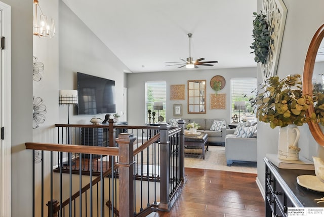 living room featuring dark wood-type flooring, a ceiling fan, and a chandelier