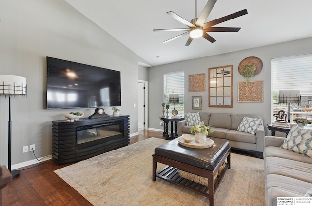 living area with a ceiling fan, wood finished floors, baseboards, and high vaulted ceiling