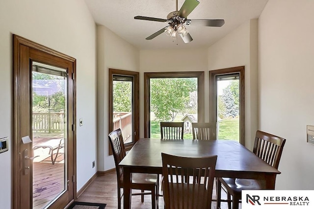 dining space with plenty of natural light, wood finished floors, ceiling fan, vaulted ceiling, and baseboards