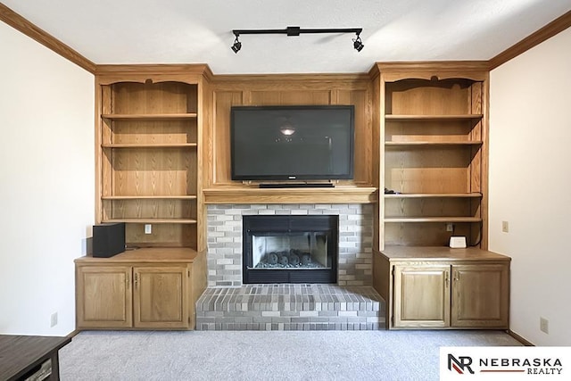 unfurnished living room with light carpet, a brick fireplace, and track lighting