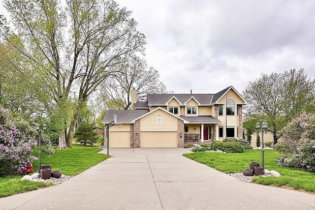 traditional-style home featuring concrete driveway, a garage, a front yard, stone siding, and a chimney
