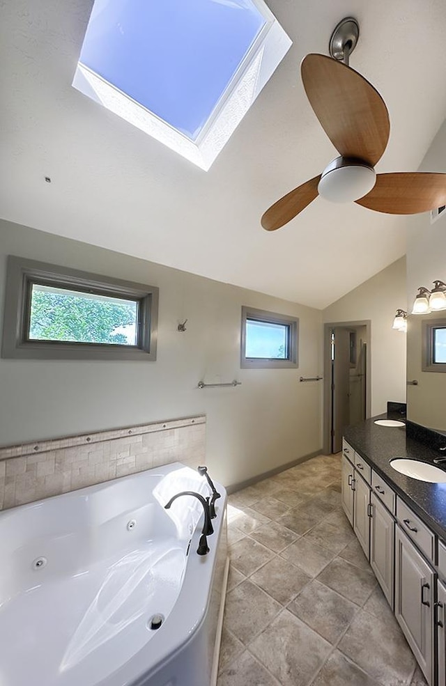 full bathroom with lofted ceiling, plenty of natural light, a skylight, a whirlpool tub, and vanity