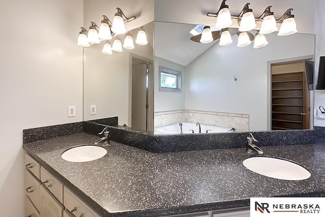 bathroom featuring vanity, a bath, vaulted ceiling, and a chandelier
