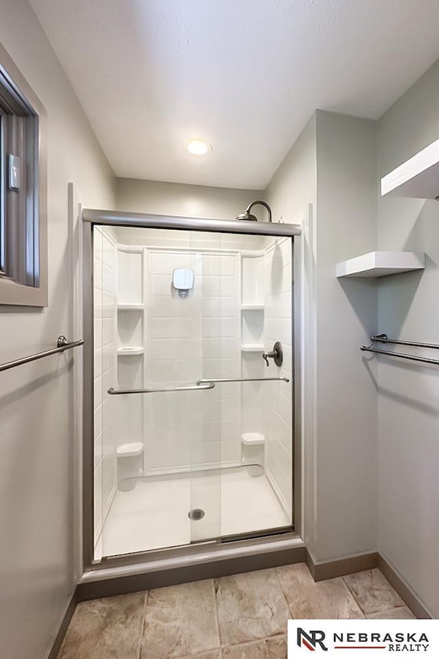 full bath featuring baseboards and a stall shower