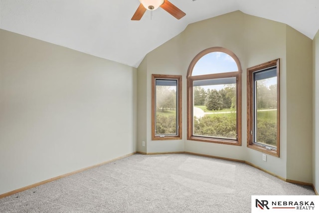 empty room with light colored carpet, healthy amount of natural light, ceiling fan, and vaulted ceiling