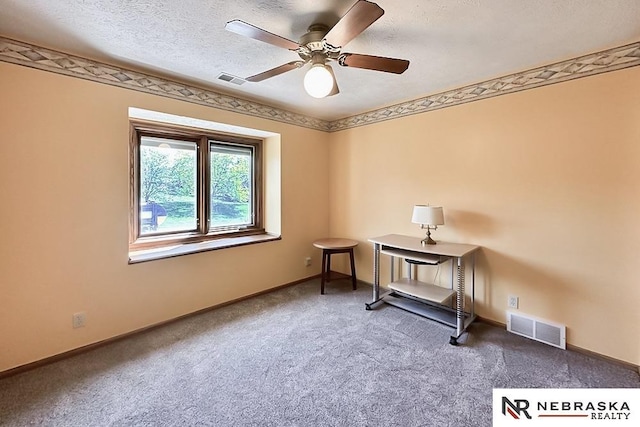 spare room with ceiling fan, carpet floors, baseboards, and a textured ceiling