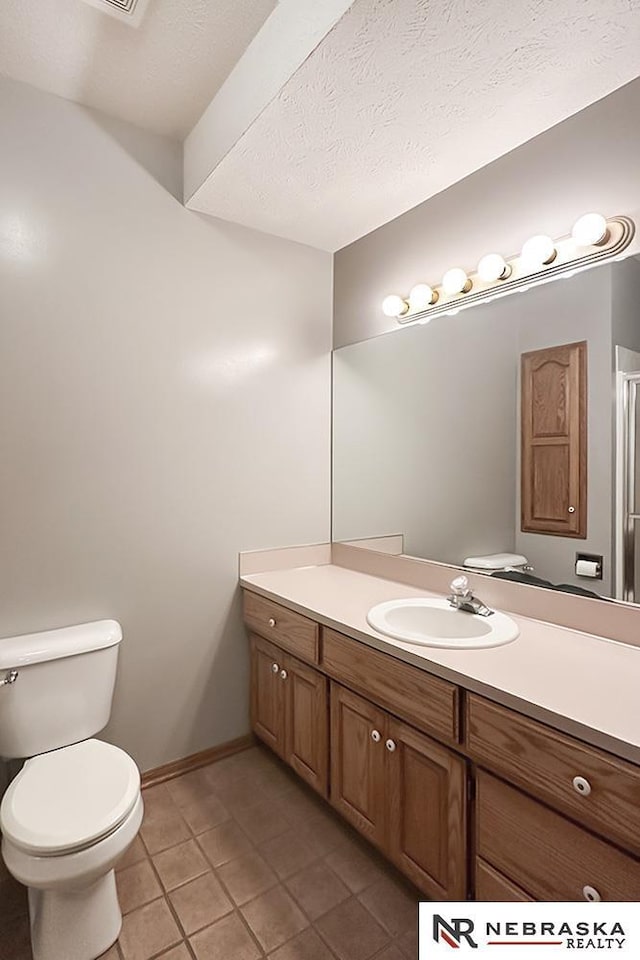 bathroom featuring tile patterned flooring, vanity, toilet, and baseboards