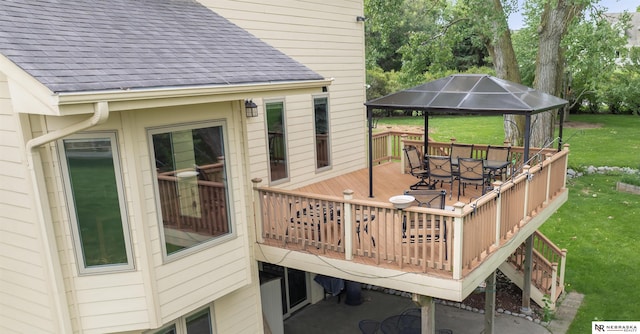 wooden deck with outdoor dining space, a yard, and a gazebo