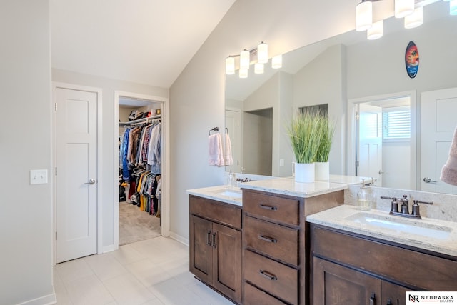 6707 S 209th St, Omaha, NE 68022 - bathroom with vaulted ceiling, vanity, baseboards, tile patterned flooring, and a spacious closet