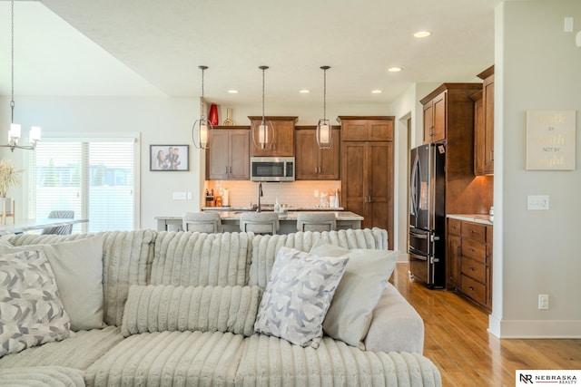 6707 S 209th St, Omaha, NE 68022 - living area with light wood finished floors, baseboards, recessed lighting, and a chandelier