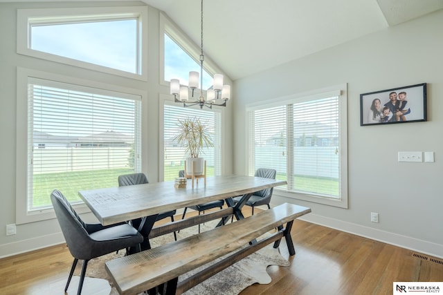 6707 S 209th St, Omaha, NE 68022 - dining area featuring baseboards, a chandelier, vaulted ceiling, and light wood finished floors